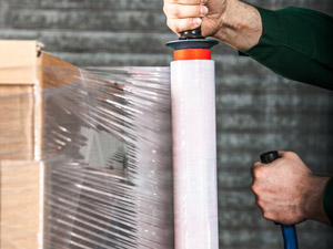 Guy stretch wrapping moving boxes